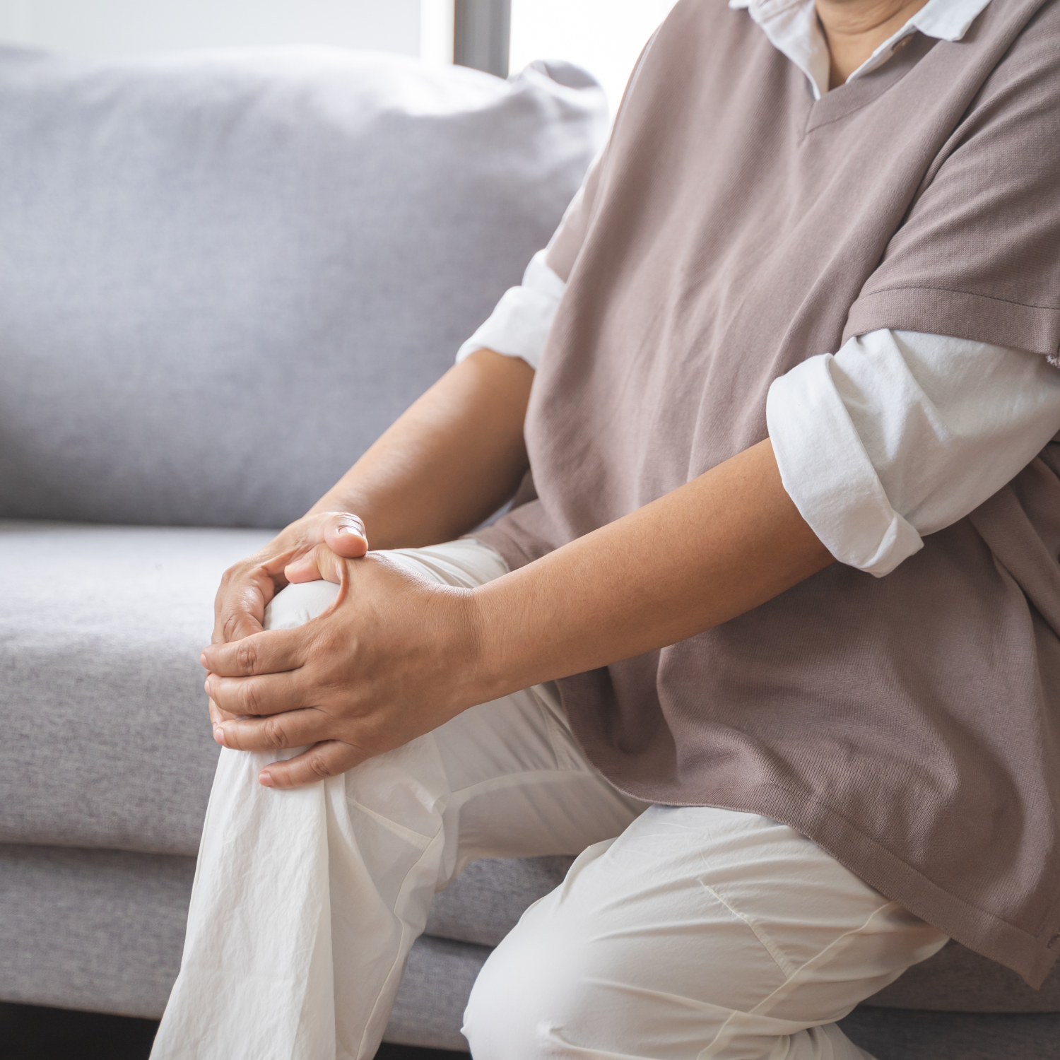 Kvinde holder hænderne om knæet - ømme muskler og led