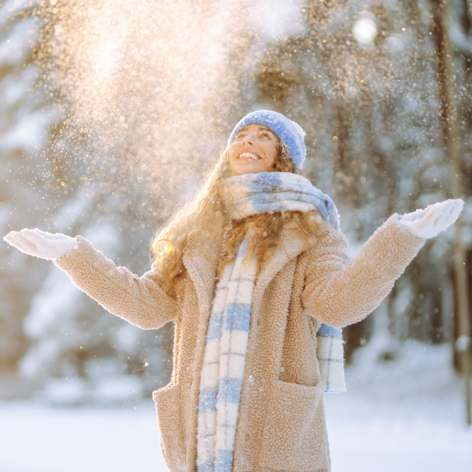 Kvinde med udstrakte arme i vinterlandskab